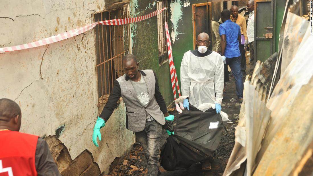 Rescuers hold a body after an overnight fire at the school that killed at least 26 children and two teachers in Monrovia, Liberia on Wednesday.