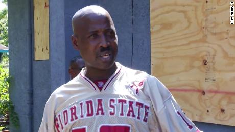 Leroy Butler stands outside his home, which is now boarded up.