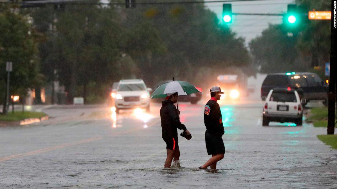 Two men wade across 19th Street in Galveston, Texas., Wednesday.