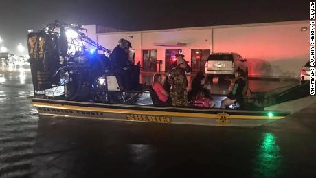 Chambers County rescuers use an airboat to ferry people to drier ground near Winnie on Thursday morning.