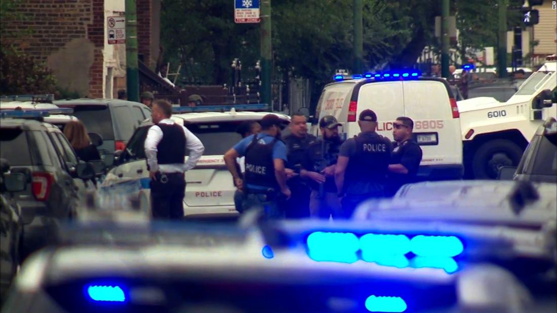 Police officers gather near the site where a Chicago officer was shot Saturday morning.