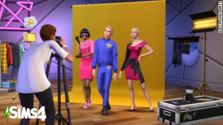 Sims characters in the game &quot;Sims 4&quot; pose in their Moschino outfits.