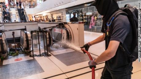 A protester uses a fire hose during a demonstration inside a shopping mall in Shatin district on September 22, 2019 in Hong Kong.