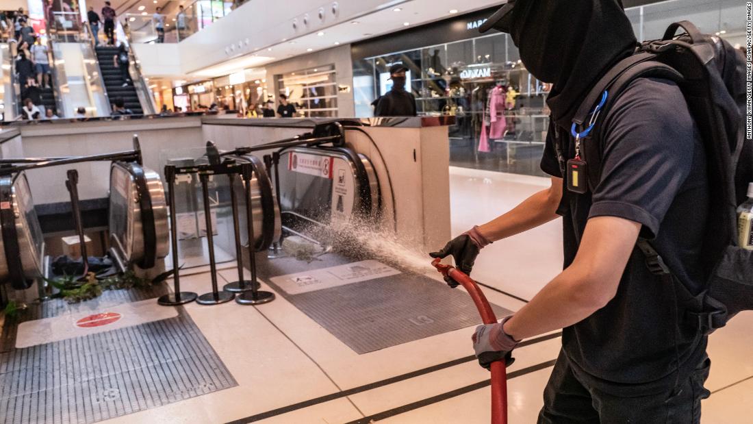 A protester uses a fire hose during a demonstration inside a shopping mall in Shatin district on September 22, 2019 in Hong Kong.