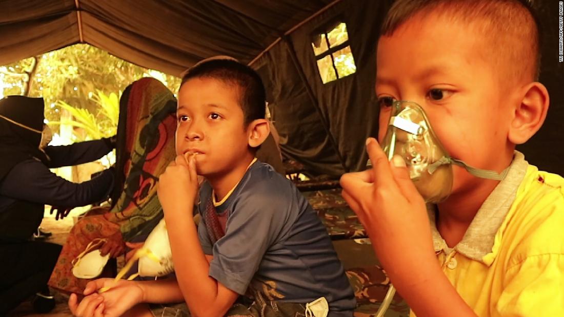 Children get a dose of oxygen from a Red Cross volunteer at a village in Jambi on September 24, 2019.