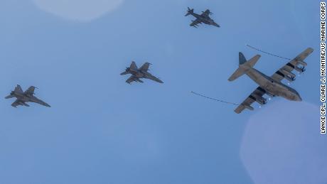 A KC-130J Hercules tanker leads an AV-8B Harrier (top) and two F/A-18 Hornets during a 2017 demonstration in California.