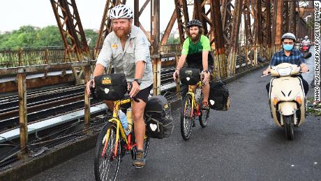 Rutland and Owens cycle on the Long Bien Bridge in Hanoi.