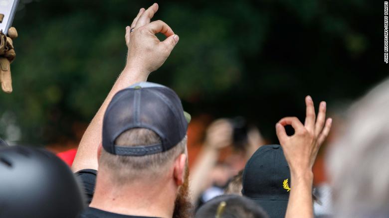 Members of the far-right group &quot;Proud Boys&quot; make the OK hand gesture at a rally in Portland, Oregon.