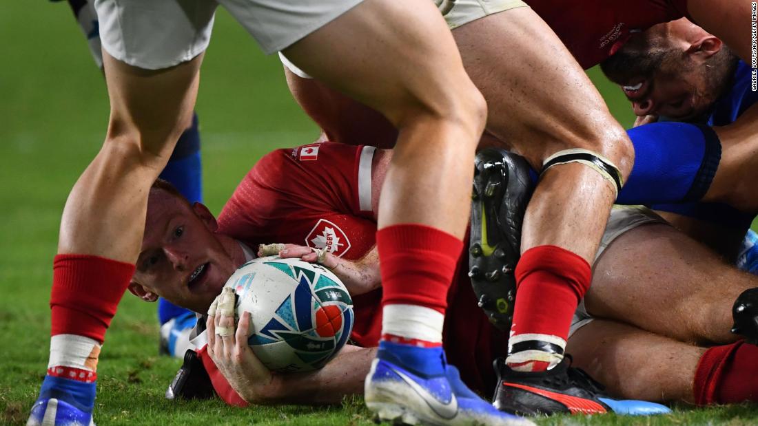 Canada&#39;s fly-half Peter Nelson hands over the ball in a ruck.