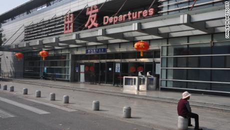 An elderly woman sits by the former departure lounge of Nanyuan Airport in Beijing, which closed on September 25.