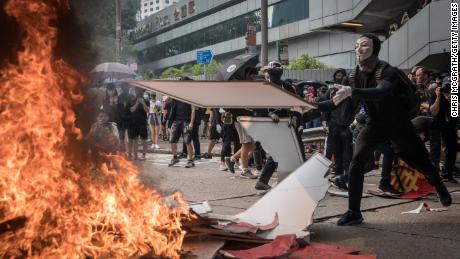 A pro-democracy protester burns a banner during a march in Hong Kong. 