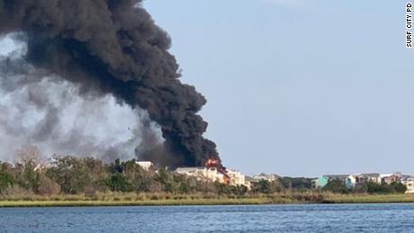 The fire appears to have engulfed multiple waterfront properties, according to pictures and video from Surf City Police&#39;s Twitter account.