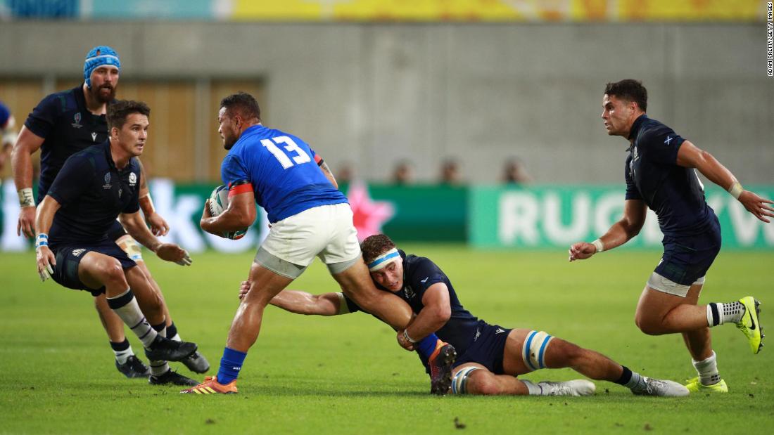 Alapati Leiua of Samoa is tackled by Jamie Ritchie of Scotland in a bruising match in Kobe. 