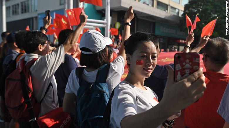 A woman takes a selfie during a pro-Beijing flash mob rally in the Tsim Sha Tsui district in Hong Kong on October 1, 2019, to mark the 70th anniversary of communist China&#39;s founding.