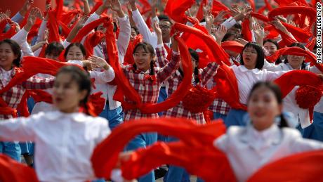 Participants wave red cloth during the National Day parade in Beijing.