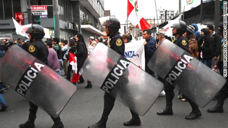 Police in LIma as demonstrators march on September 30.