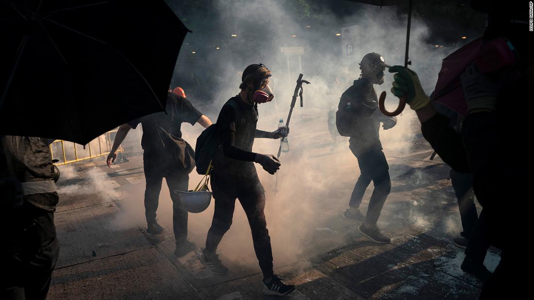 Protesters stand surrounded by smoke from tear gas shells on October 1.