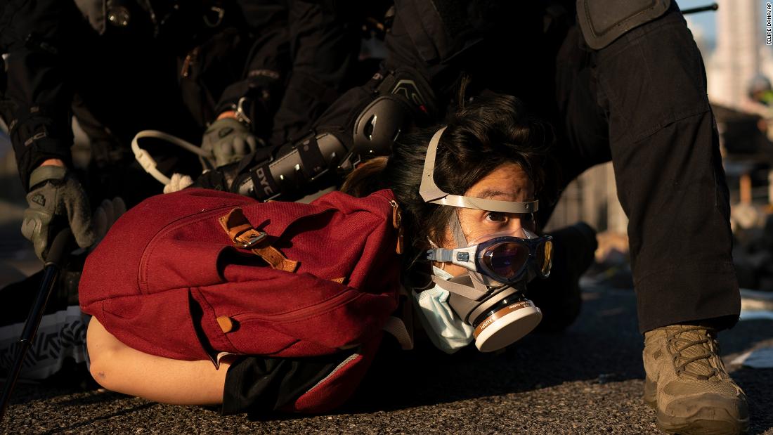 Police detain an anti-government protester on October 1. Thousands of black-clad protesters marched in central Hong Kong as part of multiple pro-democracy rallies.