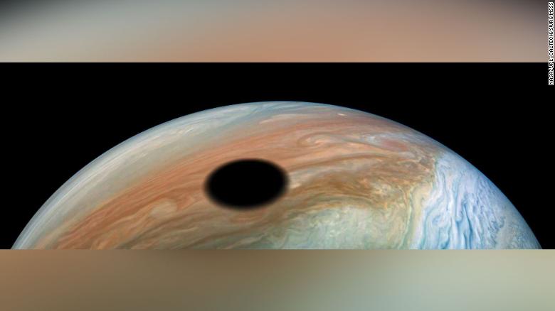 Jupiter&#39;s volcanically active moon Io casts its shadow on the planet.