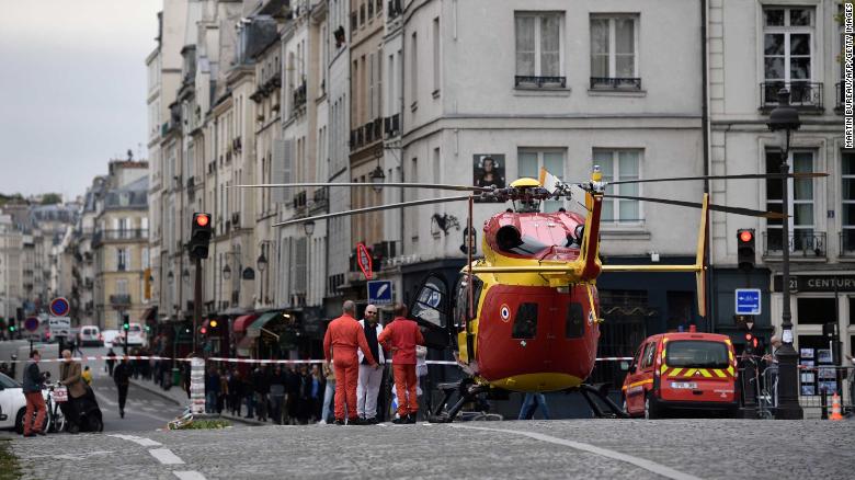 Emergency personnel stand by an air ambulance helicopter on the Pont Marie near Paris police HQ.