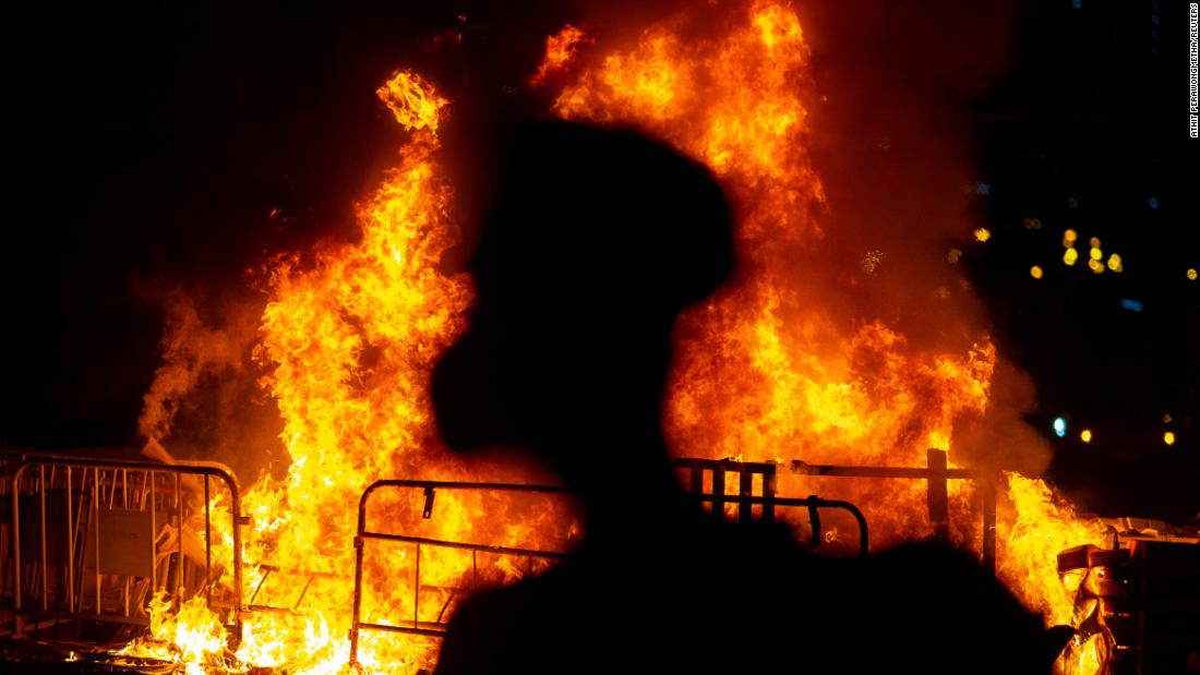 An anti-government protester stands near a fire on Friday, October 4.