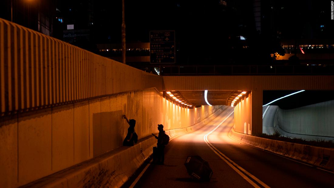 Protesters spray paint slogans at the entrance to a tunnel on October 4.