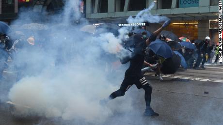 A protester throws back a teargas cannister towards police in the Wanchai district in Hong Kong on Sunday.