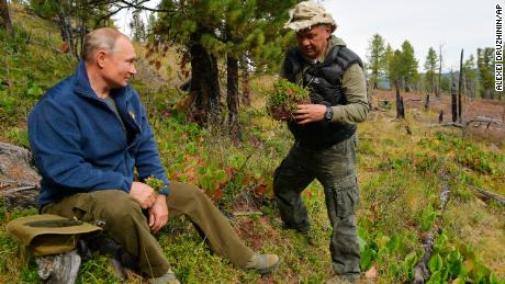 In this undated photo released by Russian Presidential Press Service, Russian President Vladimir Putin, left, talks with Russian Defense Minister Sergei Shoigu in Siberia during a break from state affairs ahead of his birthday. Russian president chose the Siberian taiga forest to go on a hike ahead of his birthday on Oct. 7.