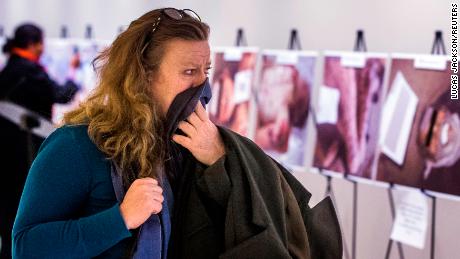 A woman reacts as she looks at a gruesome collection of Caesar&#39;s images at the United Nations Headquarters in New York.