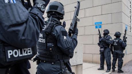 CORRECTS CITY TO DRESDEN -- Police officers secure a synagogue in Dresden, Germany, Wednesday, Oct. 9, 2019. One or more gunmen fired several shots on Wednesday in the German city of Halle. Police say a person has been arrested after a shooting that left two people dead. (Robert Michael/dpa via AP)