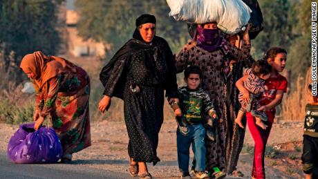 Civilians flee amid Turkish bombardment on Syria's northeastern town of Ras al-Ain in the Hasakeh province along the Turkish border on October 9, 2019. 