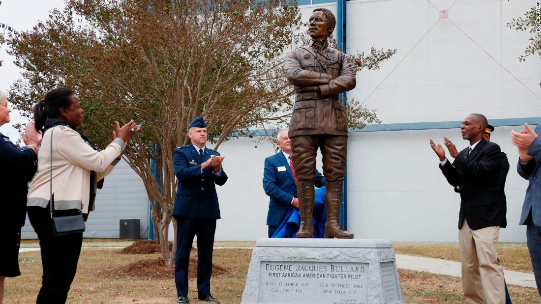 Harriett Bullard White, far left, and William Bullard, far right, join in applause after the statue of Eugene Bullard was unveiled Wednesday at the Museum of Aviation near Robins Air Force Base in Georgia.