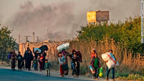 TOPSHOT - Civilians flee with their belongings amid Turkish bombardment on Syria&#39;s northeastern town of Ras al-Ain in the Hasakeh province along the Turkish border on October 9, 2019. - Turkey launched a broad assault on Kurdish-controlled areas in northeastern Syria today, with intensive bombardment paving the way for an invasion made possible by the withdrawal of US troops. (Photo by Delil SOULEIMAN / AFP) (Photo by DELIL SOULEIMAN/AFP via Getty Images)