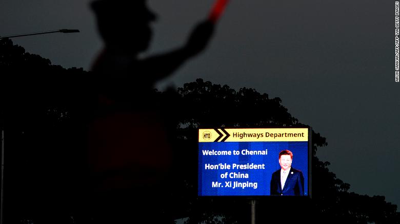A traffic policeman stands beside a welcoming board for China&#39;s President Xi Jinping in Chennai on October 9, 2019, ahead of a summit with his Indian counterpart Narendra Modi held at the World Heritage Site of Mahabalipuram from October 11 to 13 in Tamil Nadu state.