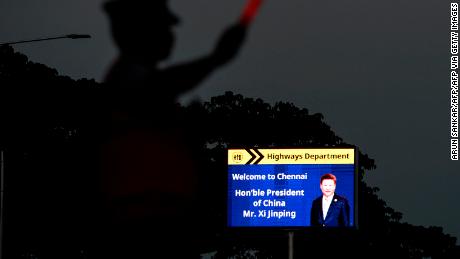 A traffic policeman stands beside a welcoming board for China&#39;s President Xi Jinping in Chennai on October 9, 2019, ahead of a summit with his Indian counterpart Narendra Modi held at the World Heritage Site of Mahabalipuram from October 11 to 13 in Tamil Nadu state.