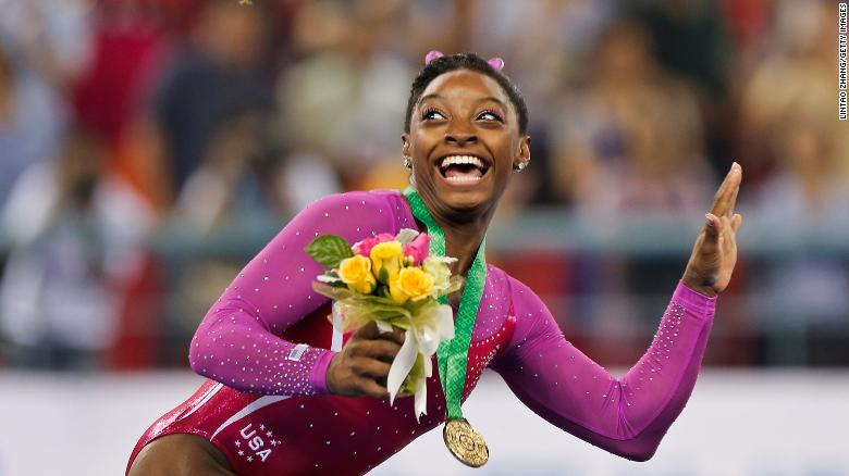Biles dodges a bee flying near her during the medal ceremony after winning gold in the all-around final of the 2014 World Championships.