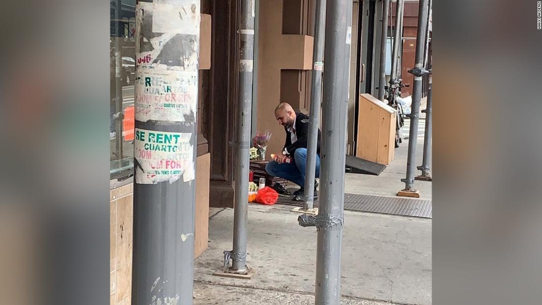 Hakki Akdeniz kneels at a memorial to the four homeless men killed in New York's Chinatown neighborhood on October 5.