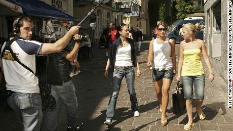 Years before starting the celebrity scandal of the century, Coleen McLoughlin (now Coleen Rooney, second right), is filmed by TV crews during the 2006 World Cup in Germany.