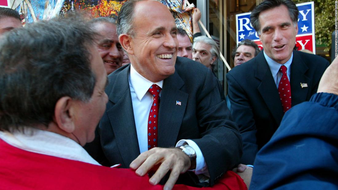 Giuliani greets people in Boston as he campaigns with Massachusetts gubernatorial candidate Mitt Romney, right, in October 2002.