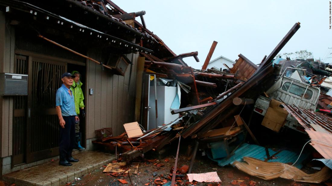 Residents survey damage caused by a suspected tornado in Ichihara, Japan, on October 12.