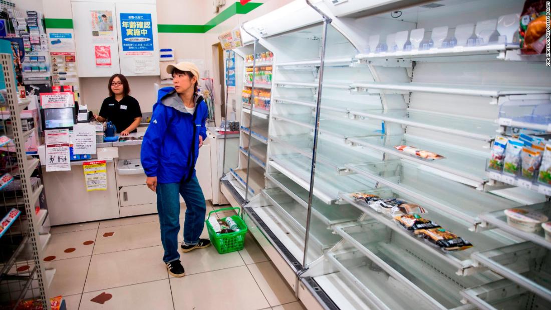 A shopper looks at empty shelves at a convenience store in Tokyo on October 12.