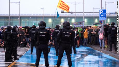 Police watch as protesters block access to Barcelona Airport on October 14. 