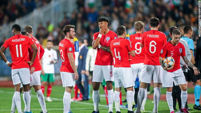 England&#39;s players wait on the pitch during a temporary interruption of the Euro 2020 game.