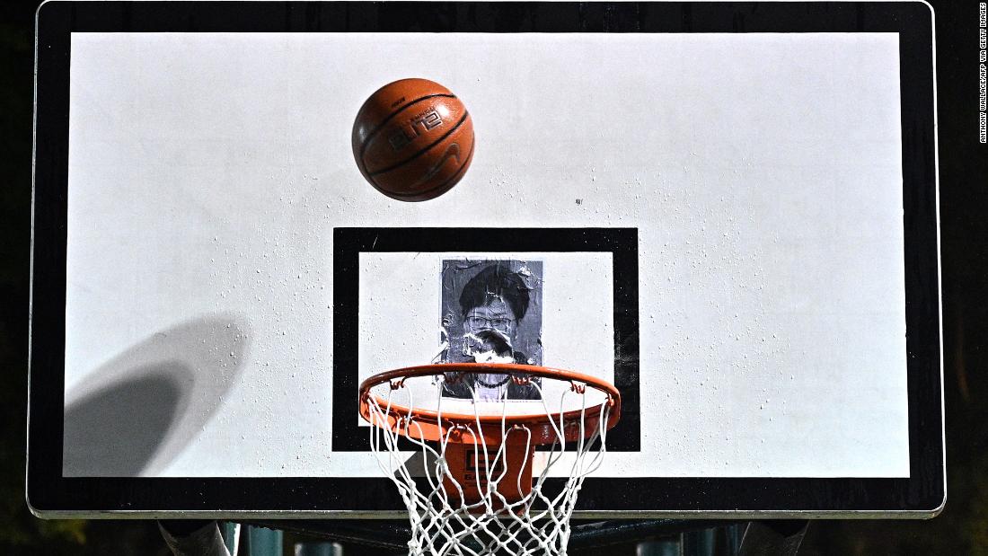 A protester shoots a basketball at a poster of Lam during a rally on Tuesday, October 15.