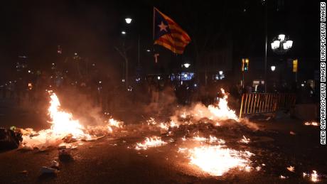 A Catalan flag flies above burning rubbish in Barcelona on October 15. 