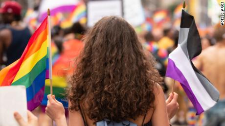 A woman carries the rainbow flag and the asexual pride flag at the WorldPride parade in New York on June 23.