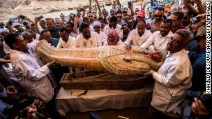 Egyptian archeologist open a coffin belonging to a man in front Hatshepsut Temple in Luxor on October 19, 2019.