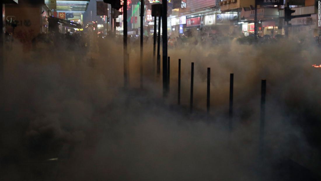 Protesters scatter as tear gas fills a street in Hong Kong on October 20.