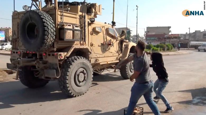 Residents angry over the US withdrawal from Syria hurl potatoes at American military vehicles in the town of Qamishli, northern Syria.