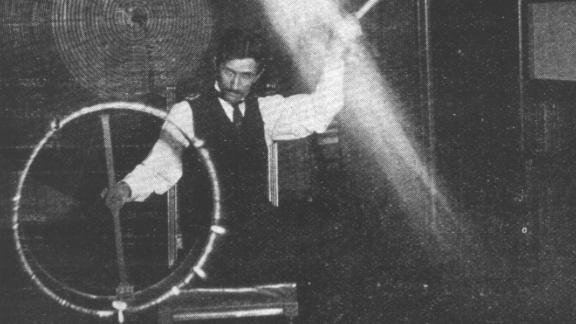 Nikola Tesla demonstrates an experiment in his New York City lab in 1895.